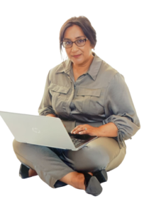 A woman sitting on the ground with her laptop.